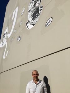 John Skandalis under his artwork in Anzac Lane