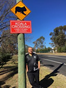 Ricardo Lonza under one of the new signs on Ben Lomond Road, Minto Heights