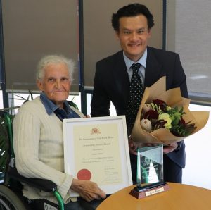 MP Anoulack Chanthivong presents a NSW Government community service award to Minto resident Laurie Porter.