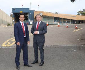 MPs Anoulack Chanthivong and Greg Warren in front of the old RTA Motor Registry site in Campbelltown.