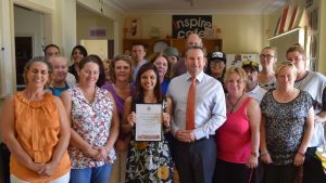 MP Greg Warren presents a certificate to One Door Harmony House for 10 years of service in Campbelltown.