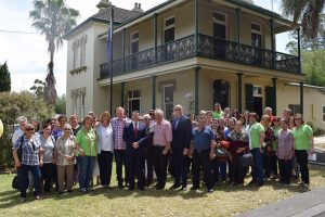 Staff and volunteers from Macarthur Diversity Services Initiative with Greg Warren (in suit) and Dr Mike Freelander in front of the renovated Manse House in Lithgow Street, Campbelltown.
