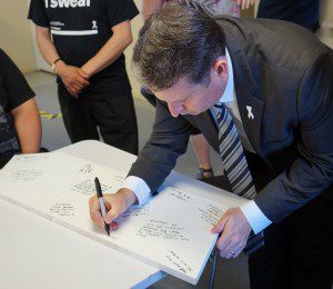 No more: the Campbelltown MP signing the pledge to stand up and speak out against domestic violence.